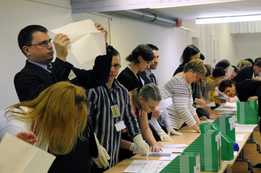 Szavazatszámlálók ellenőrzik a szavazólapokat a Nemzeti Választási Iroda budapesti székházában