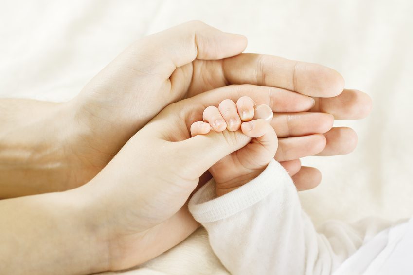 Baby hand inside parents hands. Family concept