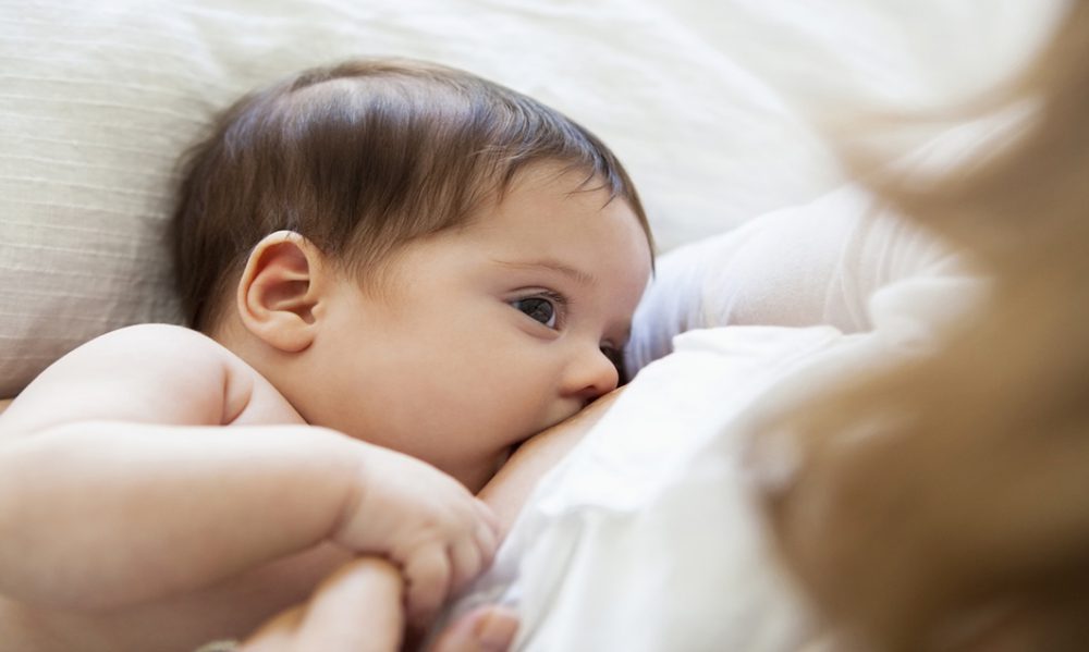 Mother breast-feeding baby girl