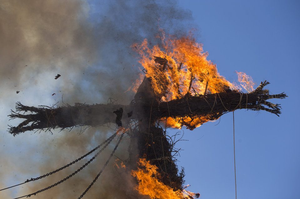 A figure representing Judas burns on a cross in the village square in Tielmes, Spain, on Easter Sunday, March 27, 2016, marking the end of Holy Week. Youths from the village who have recently turned 18 drag a tree trunk from a forest and erect it in the square with the help of older men before it's burned. The burning, originally a pagan ritual, is a cleansing ceremony to rid bad things that have happened during the year. (AP Photo/Paul White)